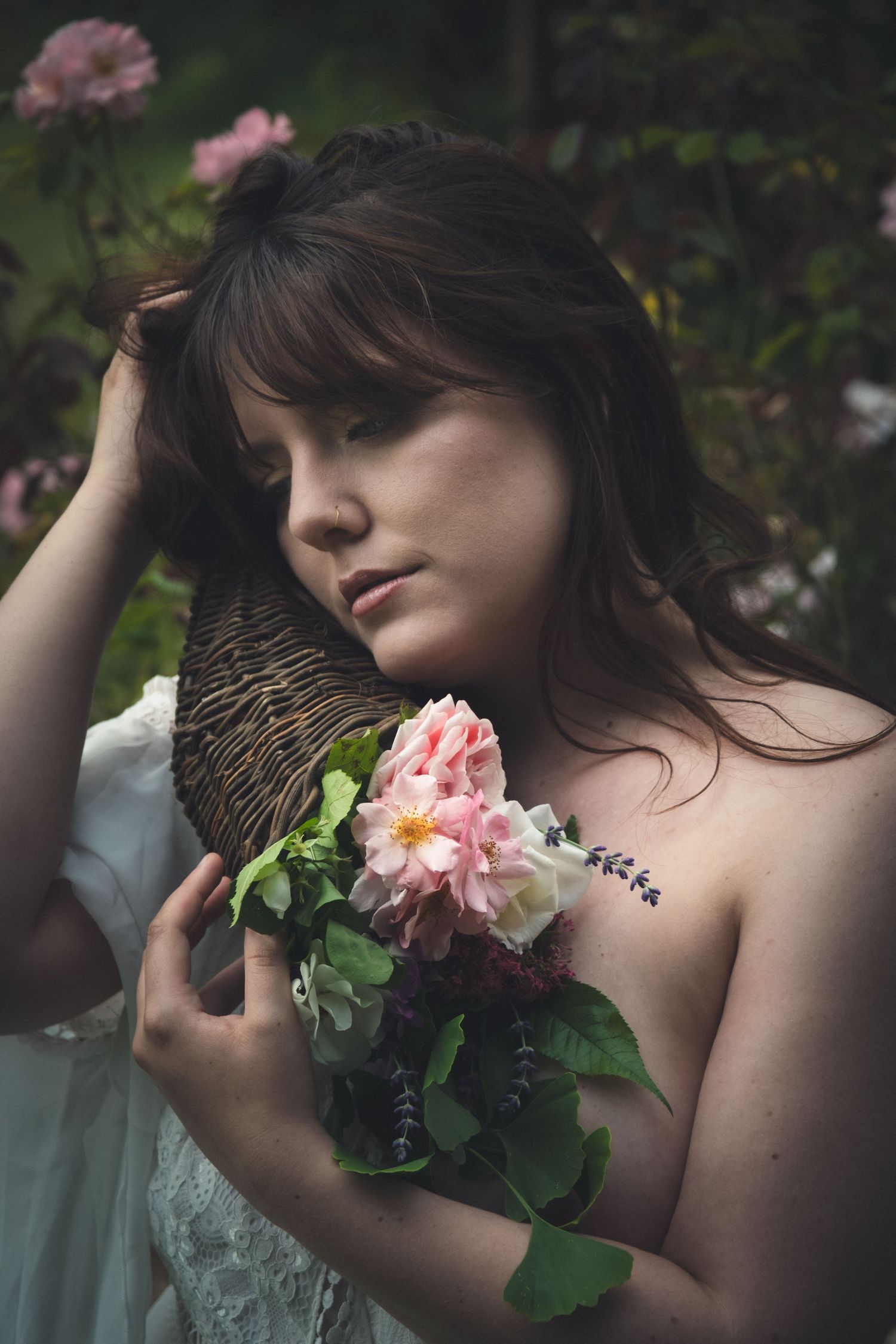 Portrait d’une femme tenant un bouquet de fleurs dans une atmosphère végétale et intimiste.
