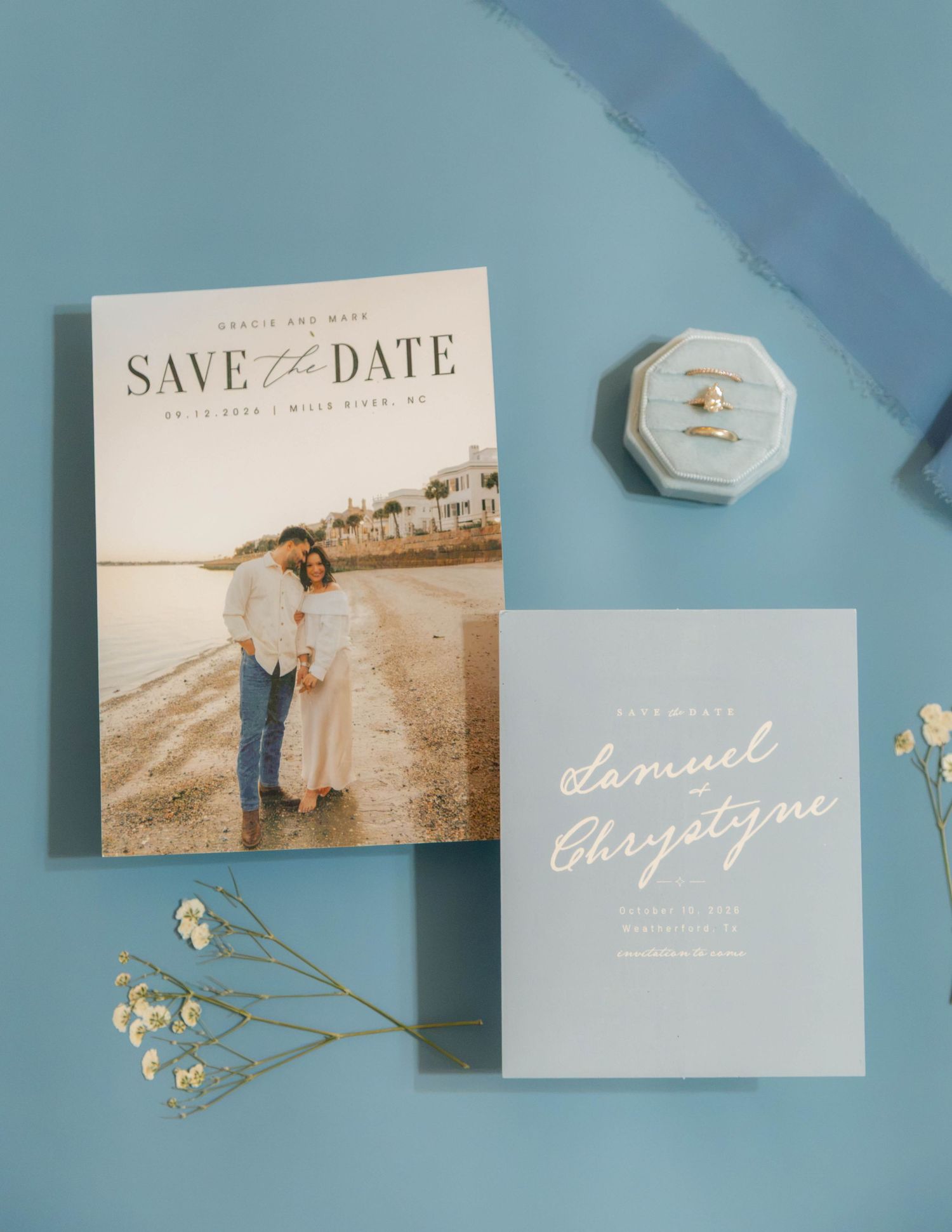 Elegant wedding save the date cards with couple photo, script typography, and ring box on blue background.
