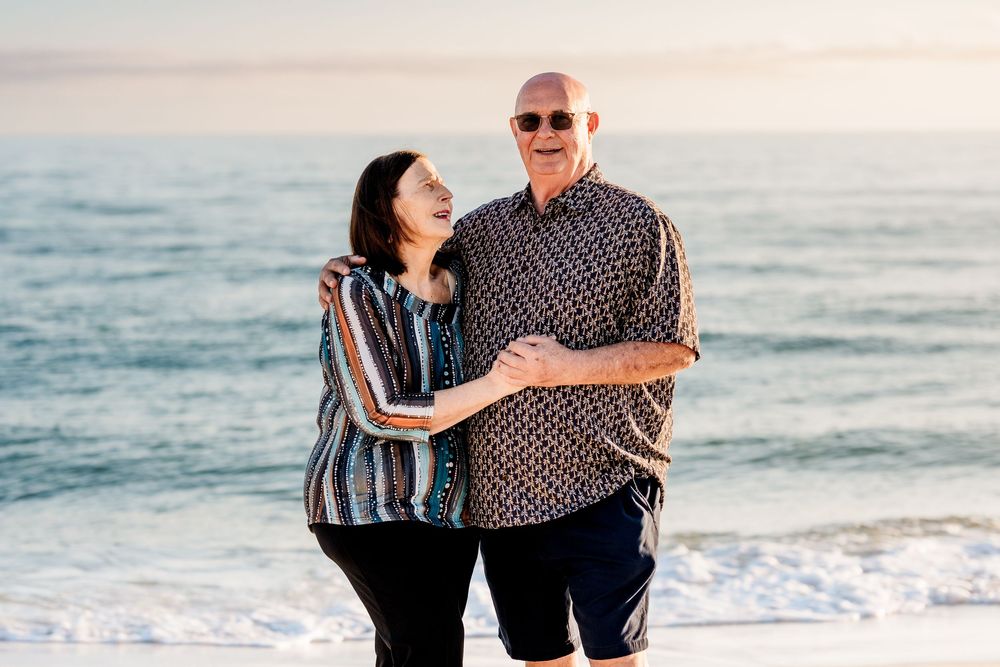 Couple laughing together by the water during a sunset beach session