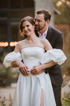 Groom whispering to the bride during a golden hour photoshoot.