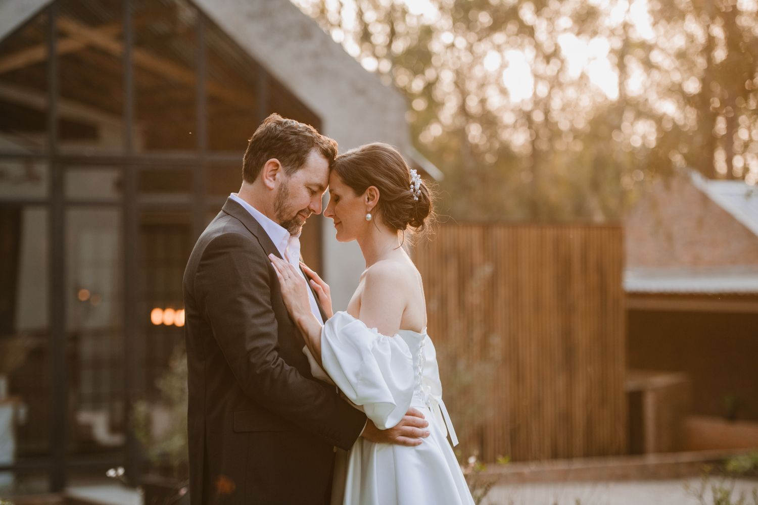 Golden hour wedding portrait of the couple in a garden setting.