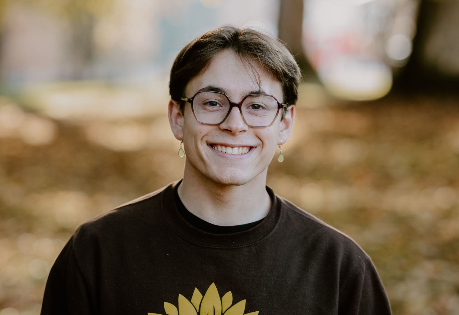 A person wearing glasses and a sunflower t-shirt smiles warmly in a sequence of portraits.