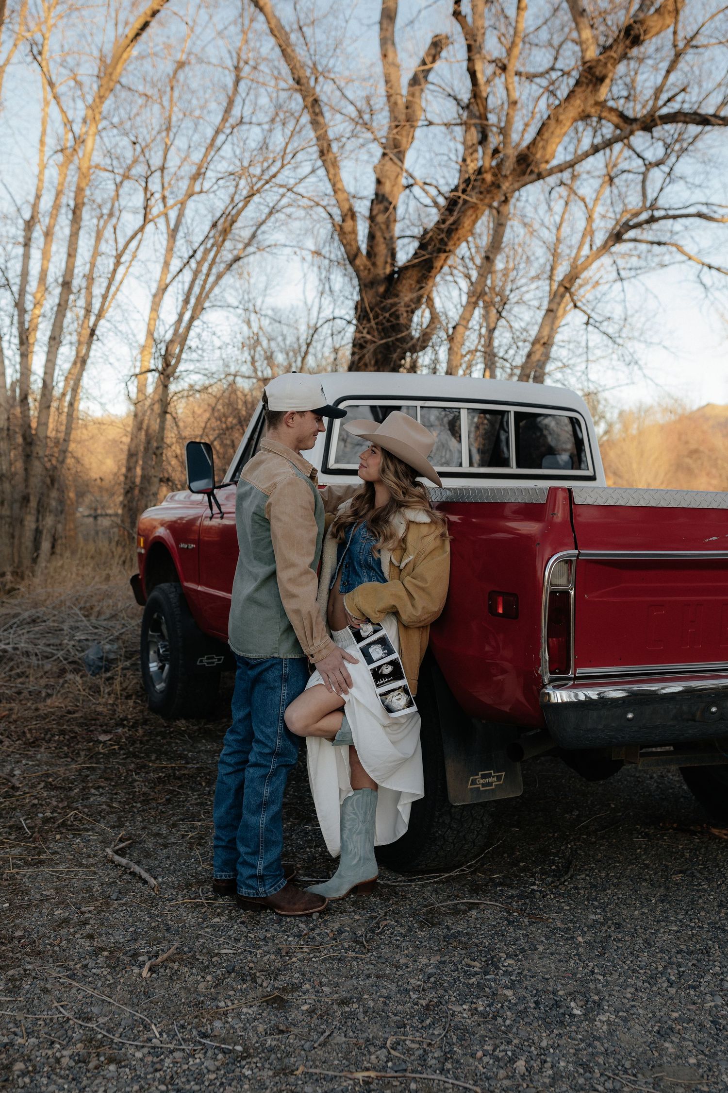 Romantic western style couple in cowboy hat sharing intimate moment against desert landscape.