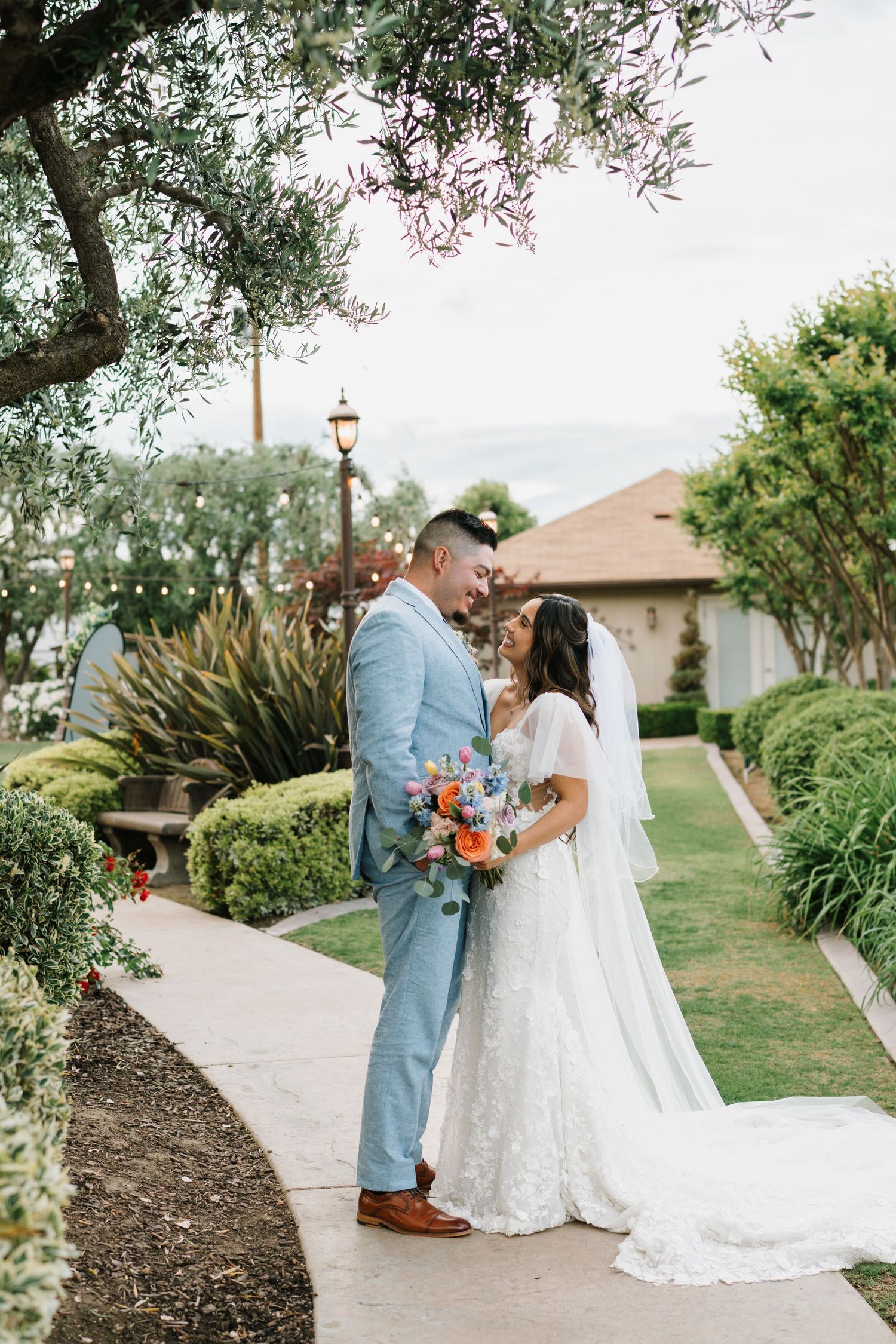 A tender moment shared under a veil with a white bouquet of flowers.