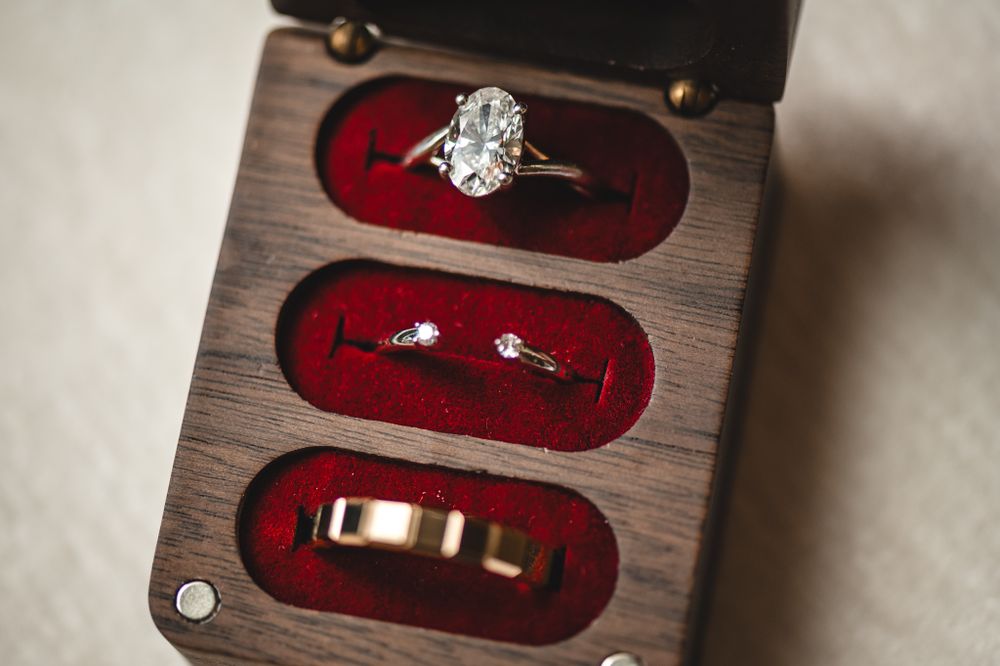 Wedding rings and jewelry displayed on red velvet cushions in elegant detail.