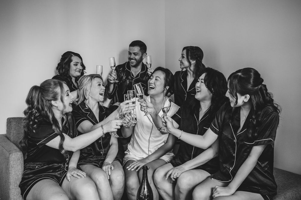 Group celebrating with champagne and laughter in black and white.
