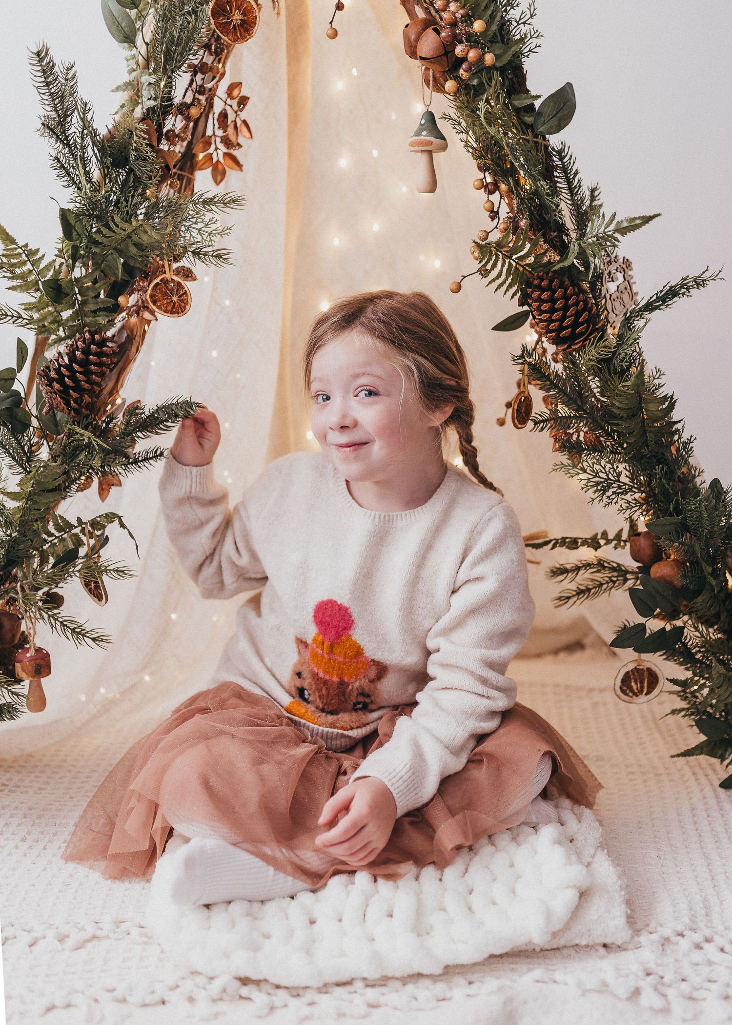 cosy warm christmas photo of little girl in natural teepee