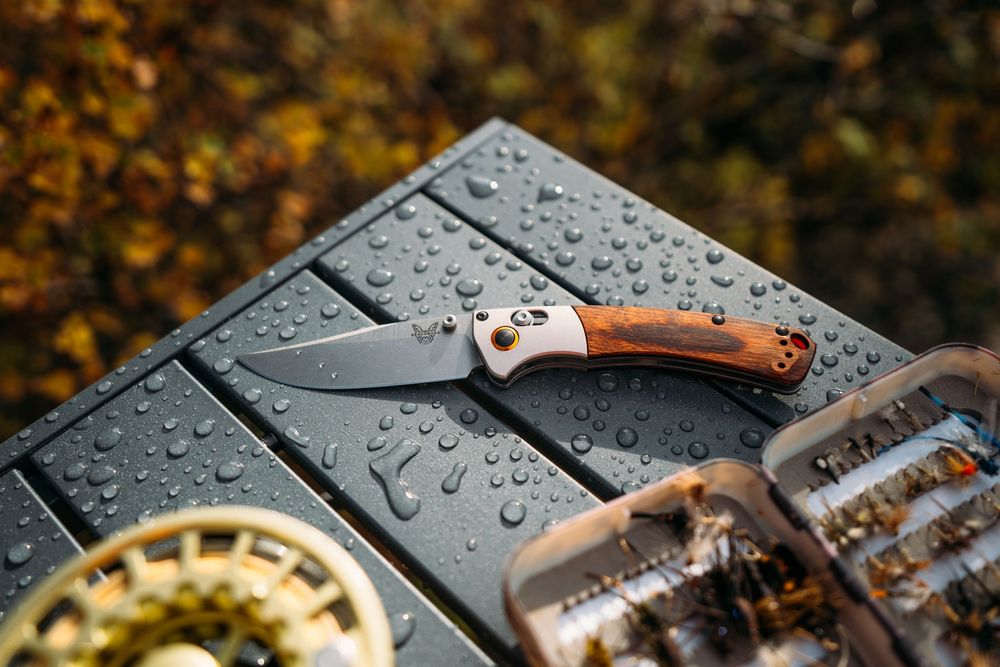 Wet camping gear and equipment with water droplets on dark surface.