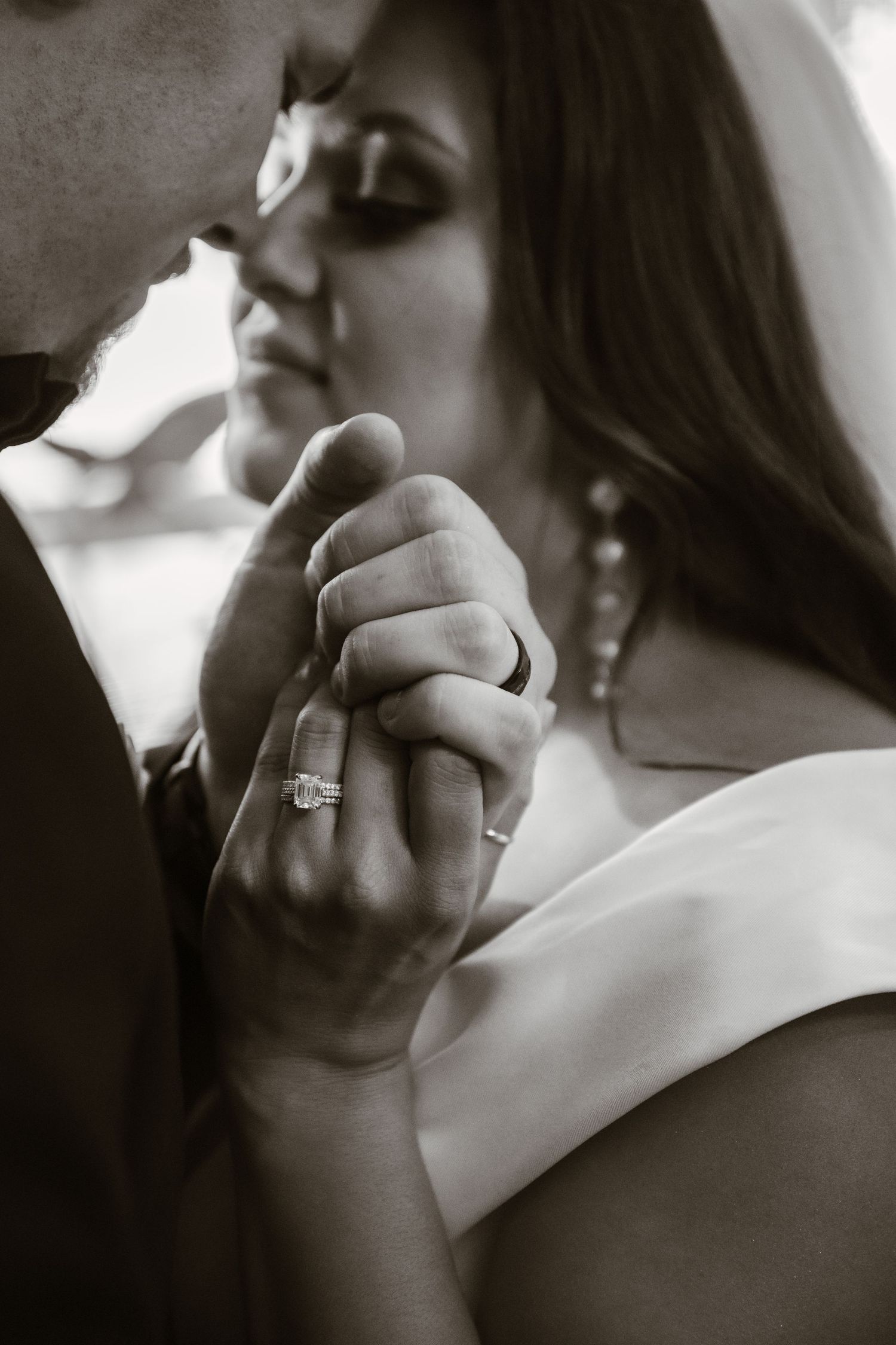 A series of close-up black and white photos showing hands with an engagement ring.