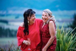 two beautiful ladies in red dresses at Amuri Estate looking out over Hanmer Springs Basin