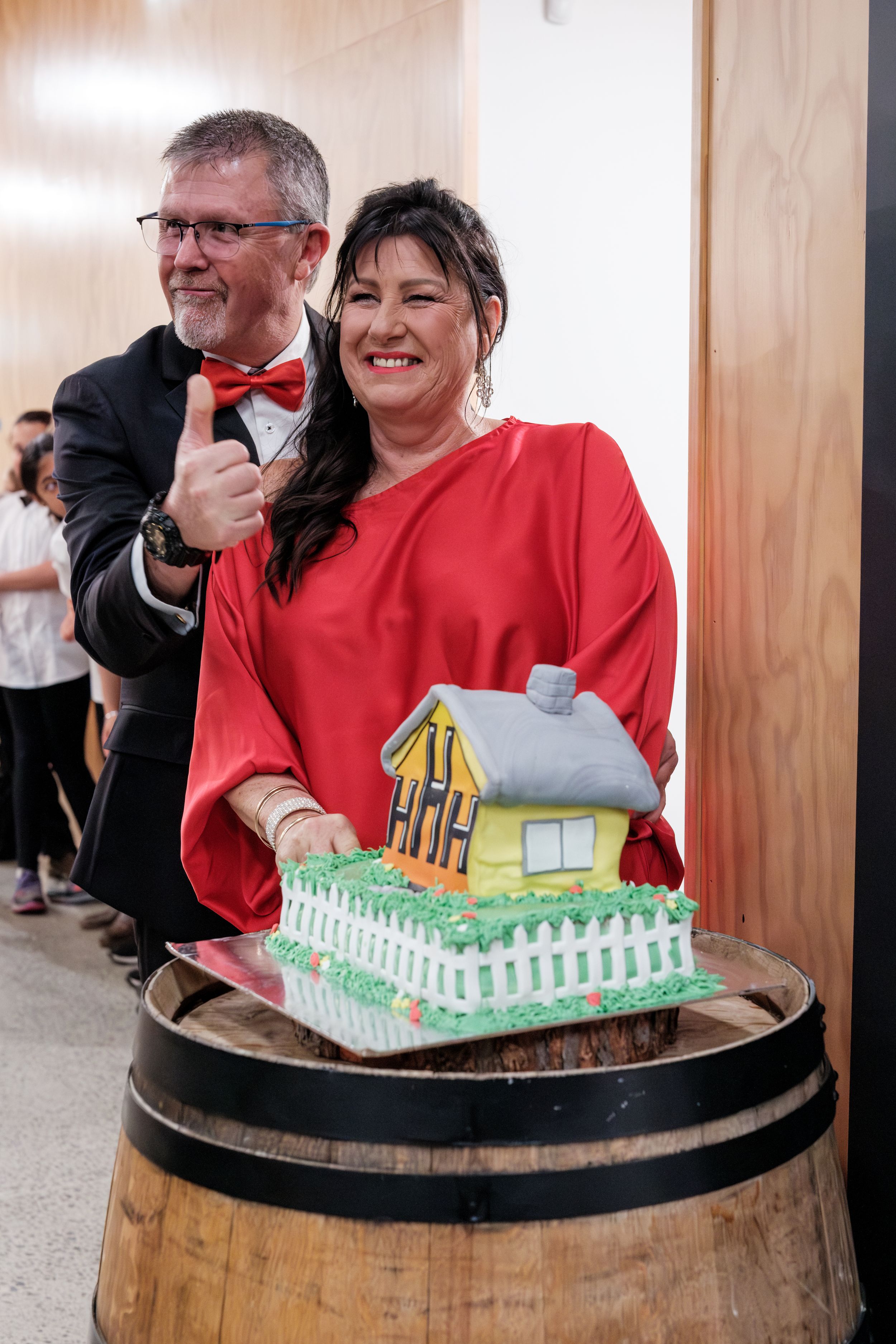 senior couple cutting birthday cake at work birthday function