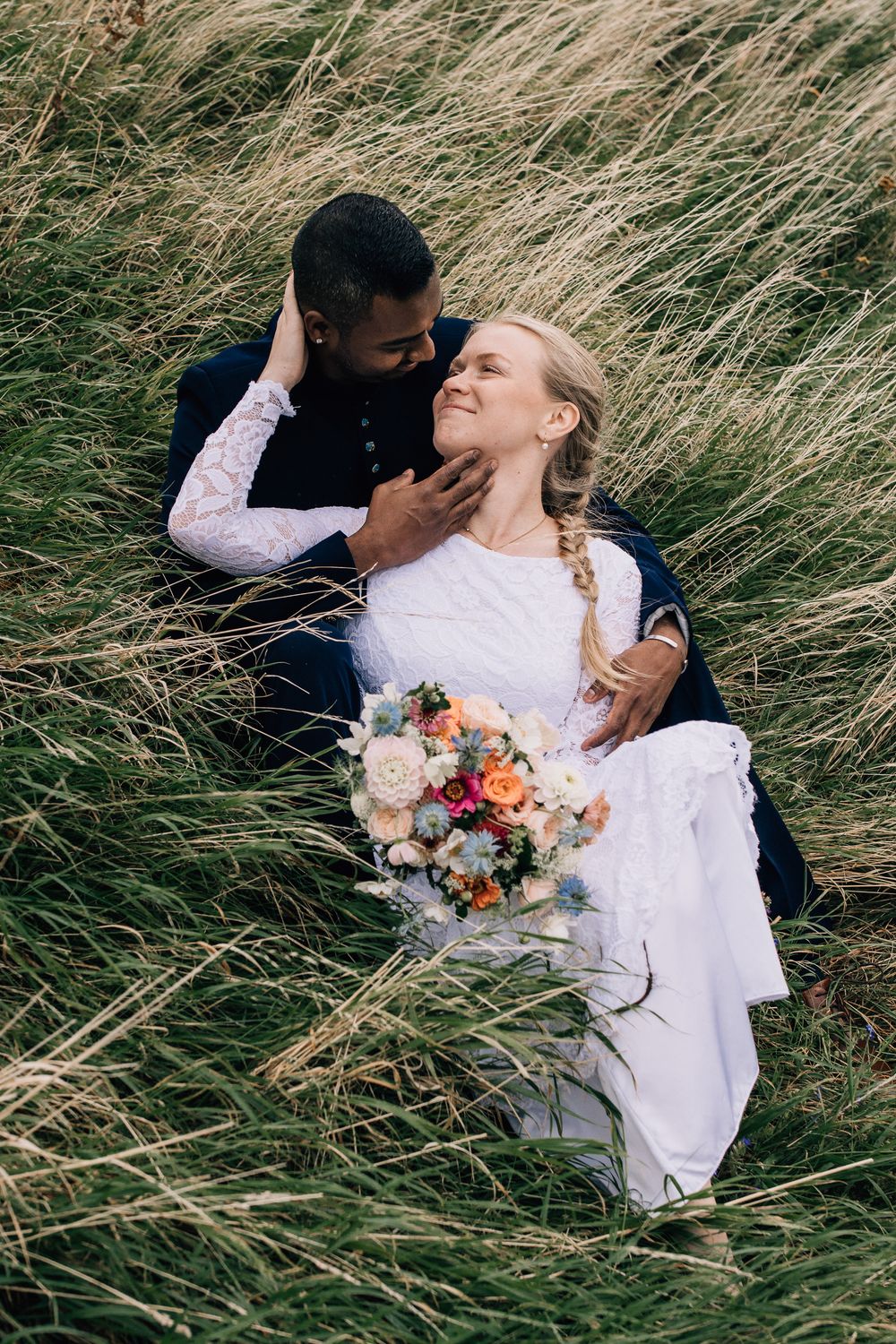 Fotograf fotar brudpar i gräset i Varberg.