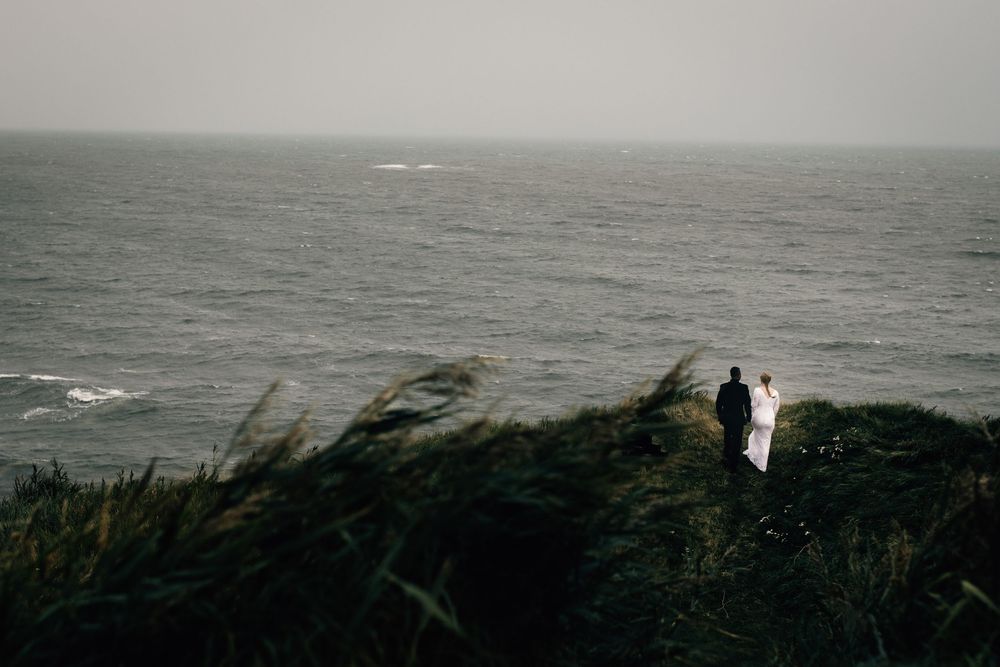 Bröllopsfotograf som fotograferar brudpar i Varbergsfästning när det stormar