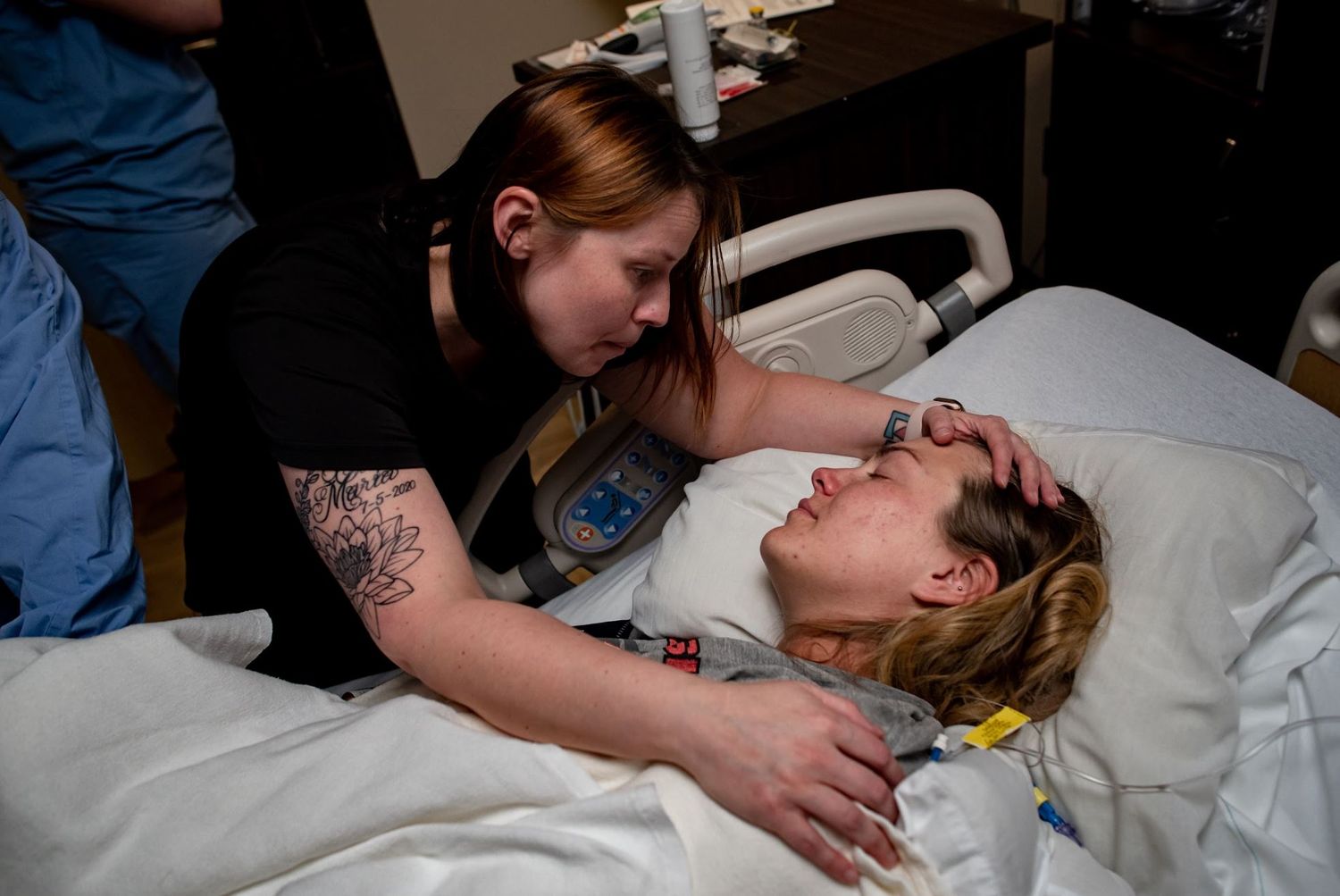 Doula providing supportive care in hospital birth room.