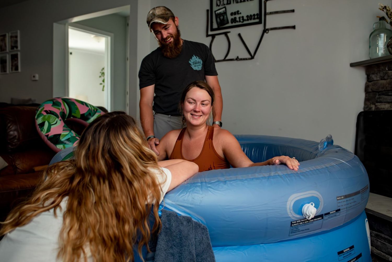 People gathered around a blue inflatable birthing pool during labor.