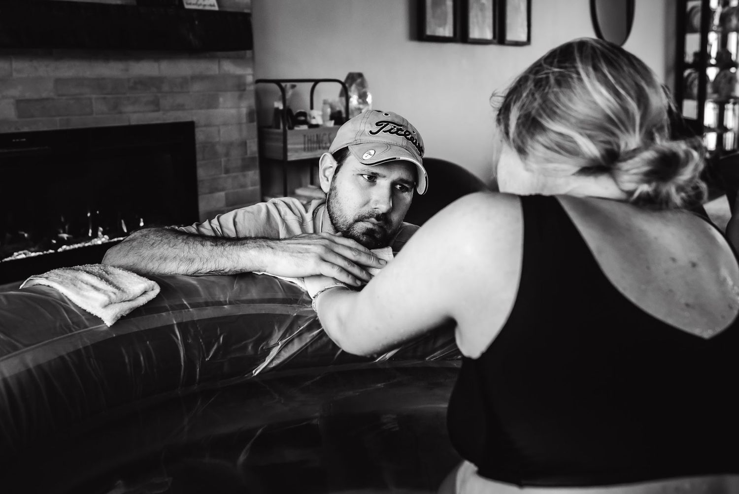 Support person provides comfort during labor in home birth setting.