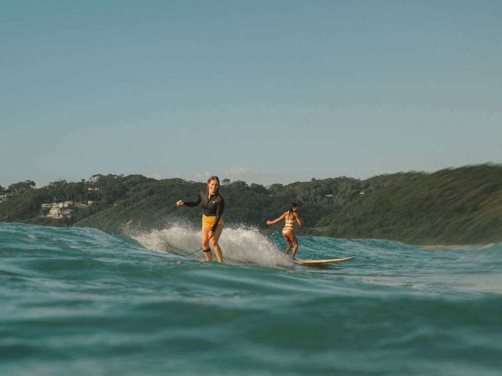 two girls on an A frame wave taking each side on a group social surf with Sunlight Surfers Dudley Newcastle NSW
