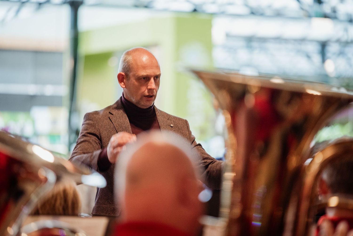 Ieder orkest heeft kundige aansturing nodig. Foto van de dirigent vanuit perspectief van de groot koper blazers door Anneke Timmermans
