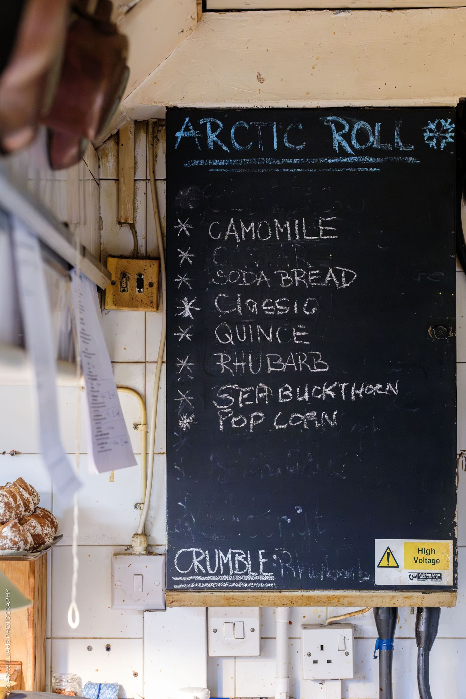Chalkboard menu for Arctic Roll desserts listing camomile, soda bread, classic, quince, rhubarb, sea buckthorn, and popcorn flavors.