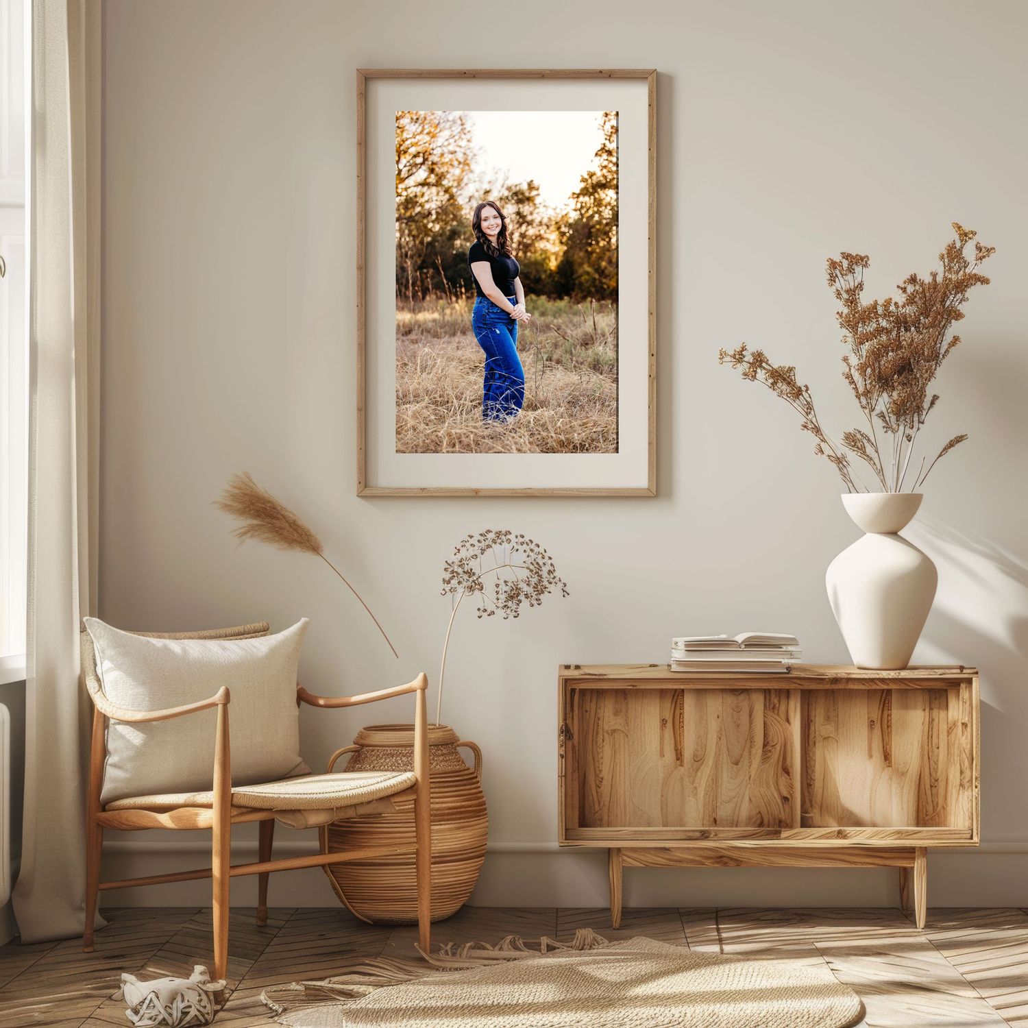 A framed portrait of a young woman in a field in Fort Worth, displayed in a warm, minimalist living room with natural wood furniture.