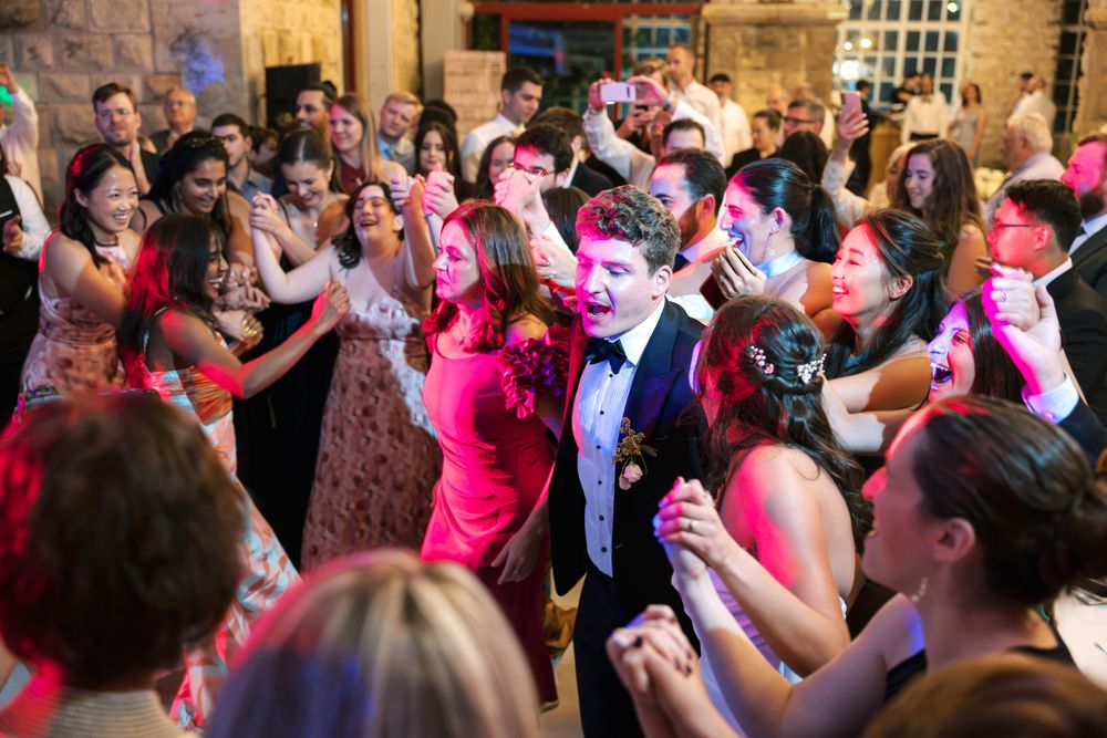 Bride and groom celebrating with friends on the dance floor during wedding reception