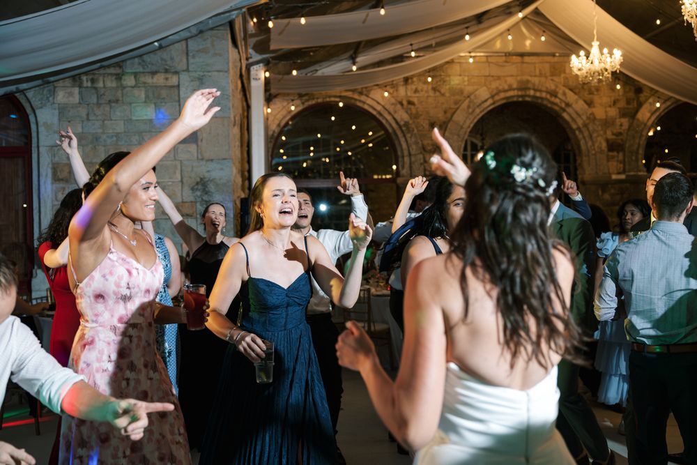 Friends and family dancing together during wedding reception at Forte da Cruz