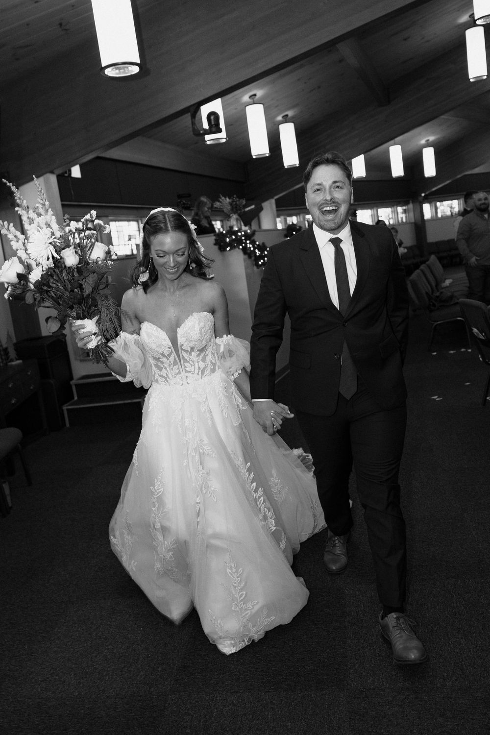 Joyful bride and groom walk hand in hand down the aisle after their wedding ceremony.
