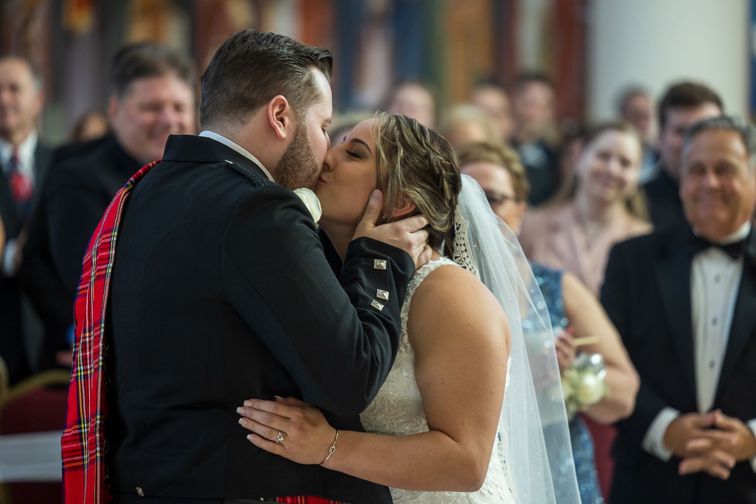 Bride and groom share their first kiss at the altar during a wedding ceremony in a church.