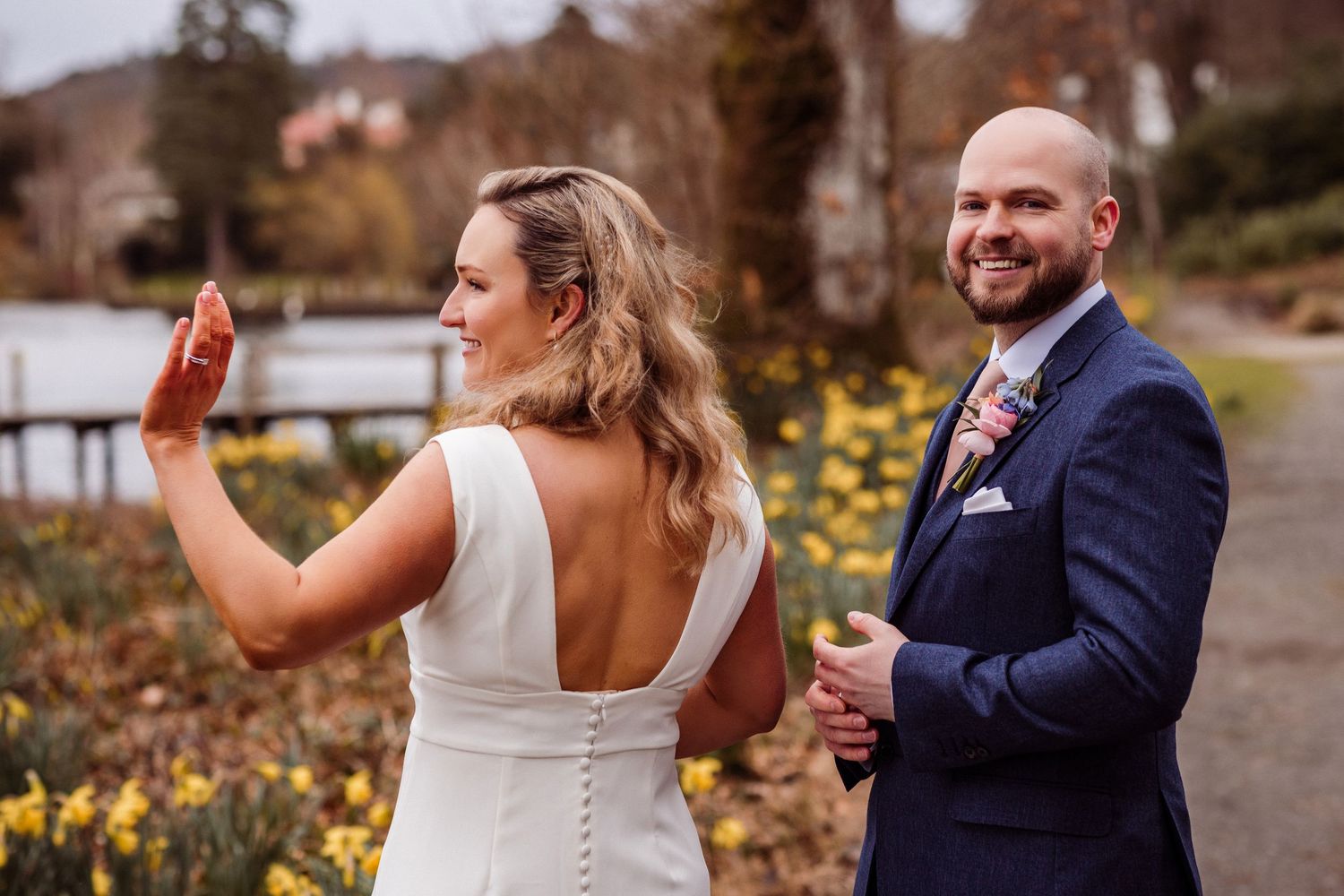 Couple waving at passing boat at Storrs Hall, daffodils in the background