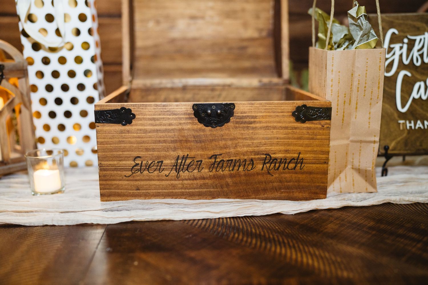 Farmhouse style table decor featuring polka dot runners and black wooden sign accents at a rustic event venue.