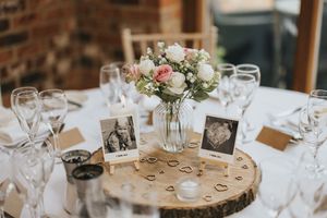 Wedding reception table settings feature votive candles and white floral centerpieces at Hall Farm - image captured by Grimsby photographers
