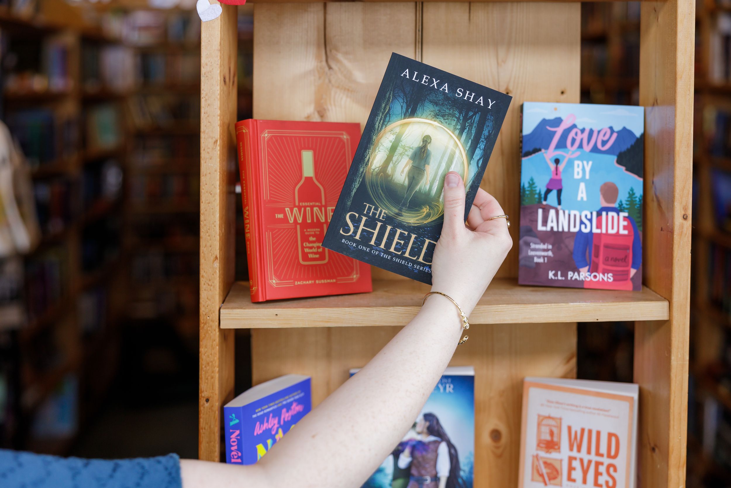 indie book author Alexa Shay author signing event in Seattle, WA bookstore lifestyle pulling The Shield from display book shelf to purchase