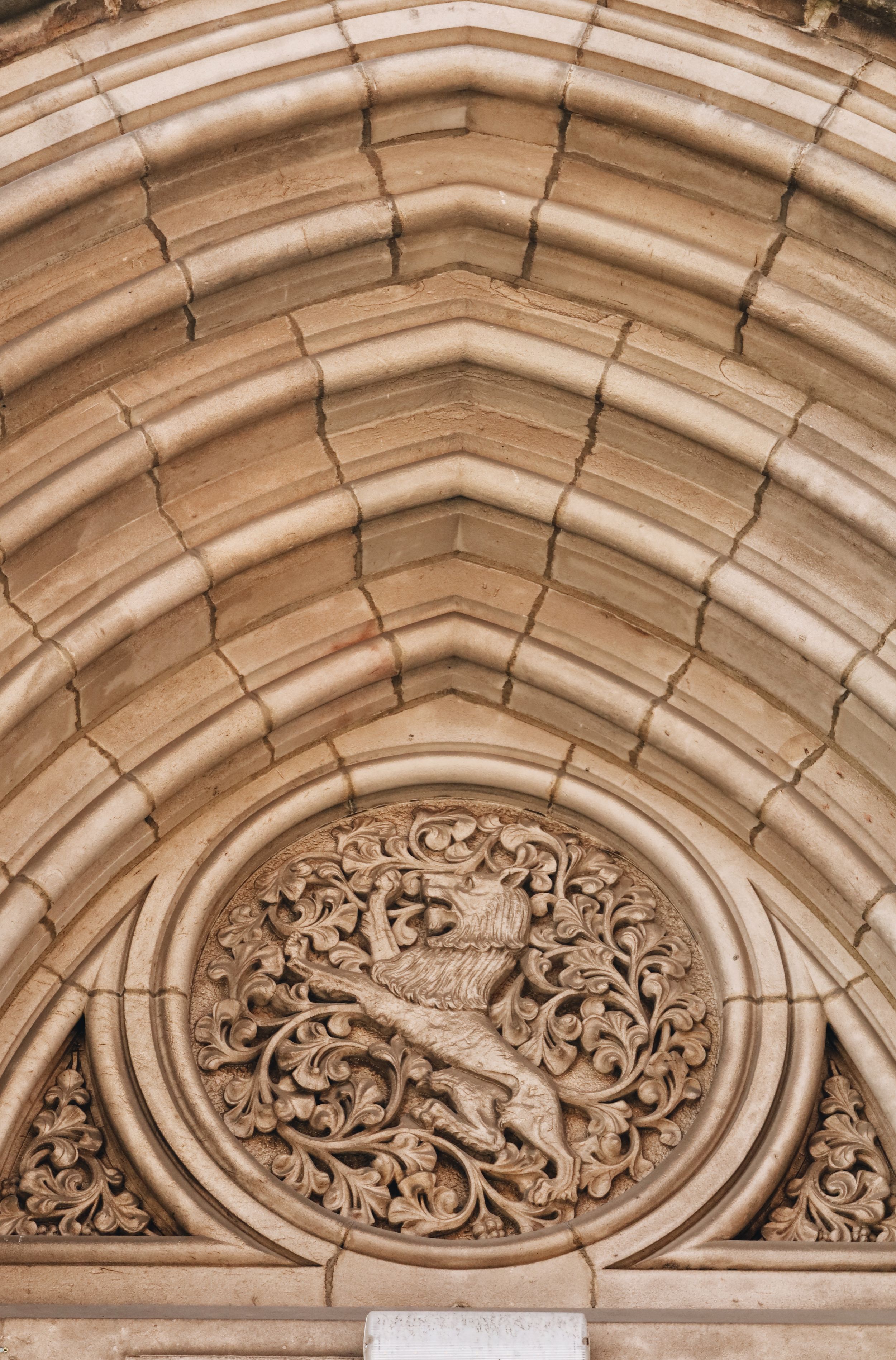 Detailed architectural stone carving above an arched doorway or window.