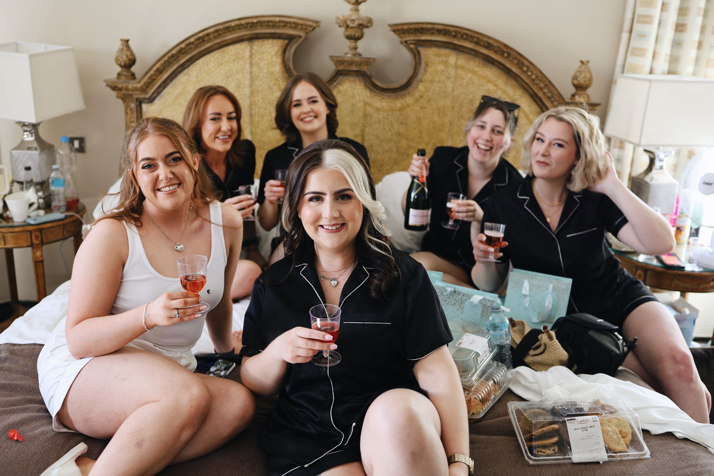 Wedding party guests enjoying champagne and conversation in an elegant room.