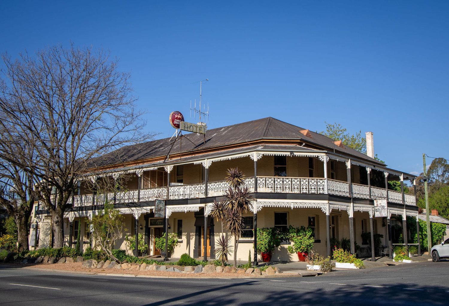 Historic two-story hotel building with wraparound veranda and Victorian architecture.