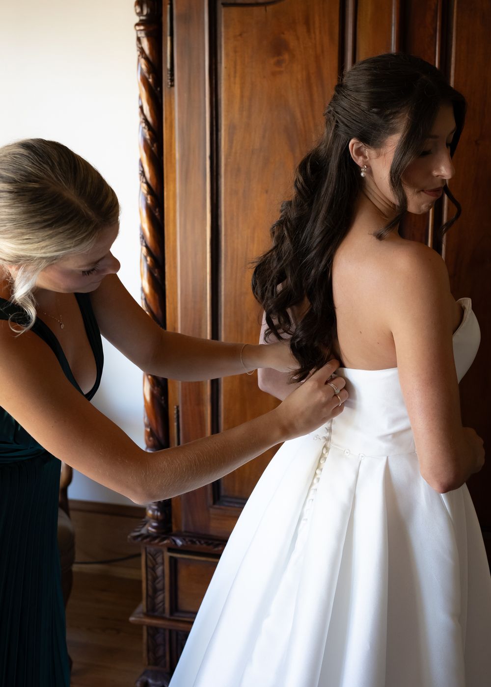 A series of photos showing someone adjusting a white wedding dress in a wood-paneled room.