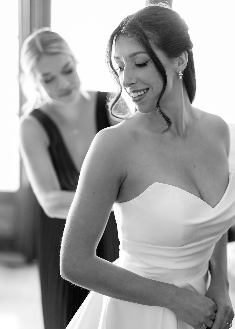A series of candid black and white photos showing bridesmaids in white dresses helping with wedding preparations.