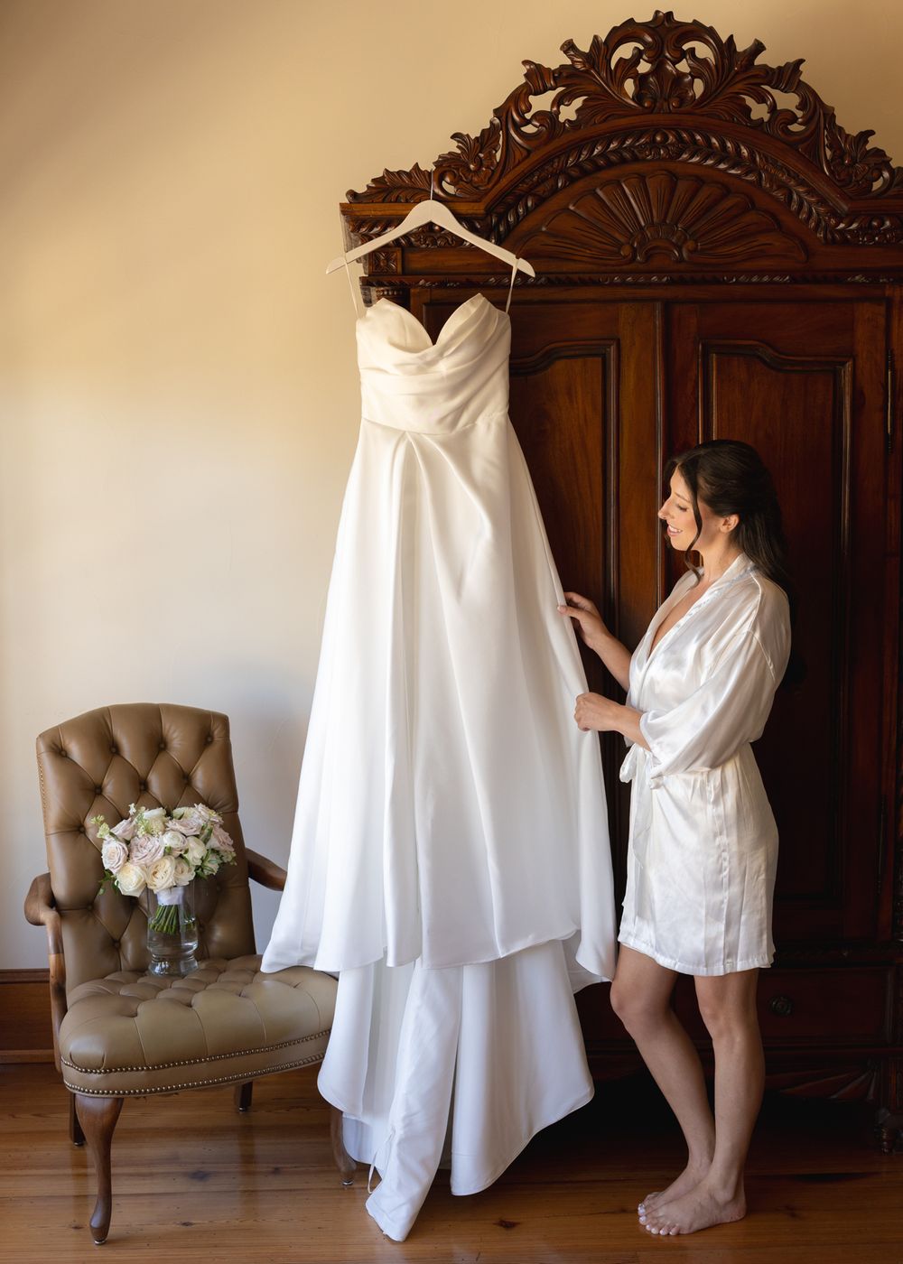 A sequence of photos showing someone getting ready in a white robe against an elegant wooden wardrobe and beige chair.