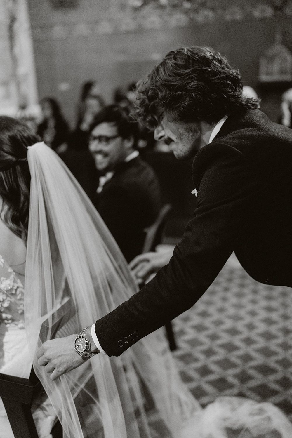 A sequence of black and white photos showing a couple during their first kiss at a wedding ceremony.