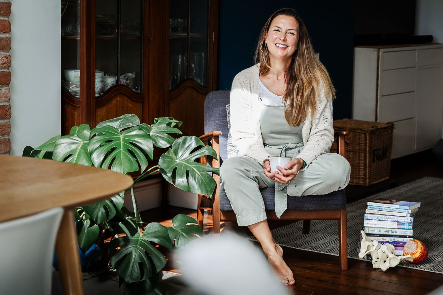Relaxed Bristol brand photoshoot at home with doula Rebecca Hunt. Photo shows a woman smiling to camera holding a cup of tea.