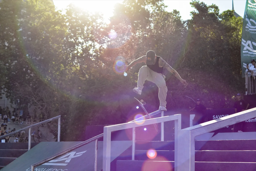 Skateur en l’air au-dessus d’un module, lumière de fin de journée en contrechamp.