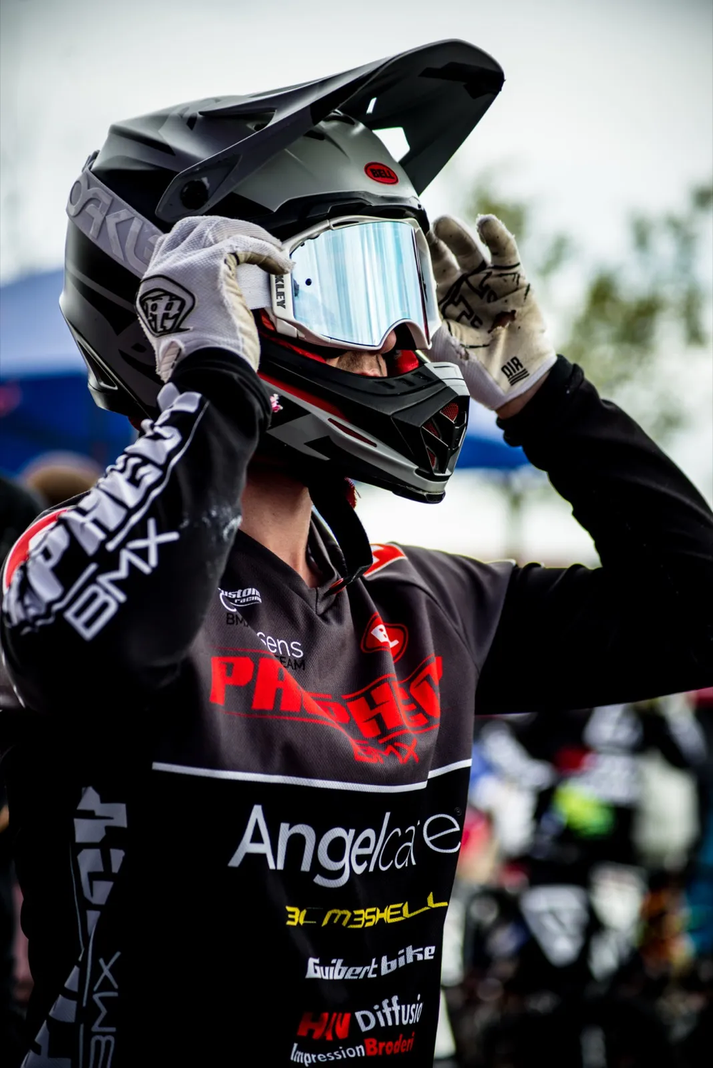 Rider en tenue noire ajustant son casque intégral, prêt à s’élancer.