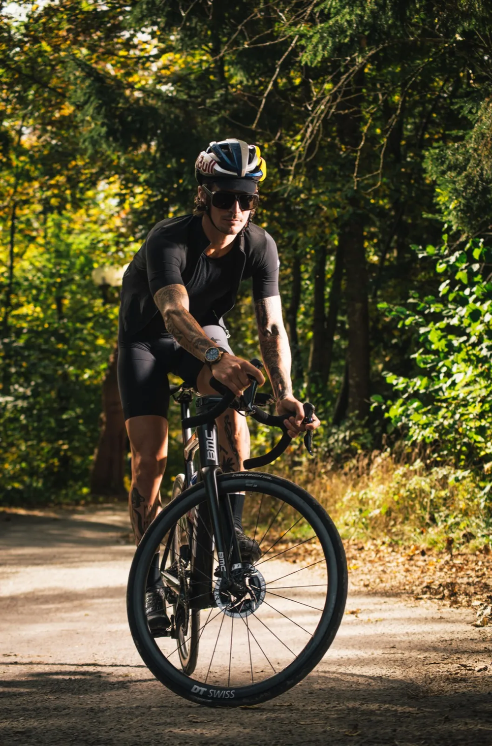 Cycliste dans un chemin forestier, lumière dorée de fin de journée.