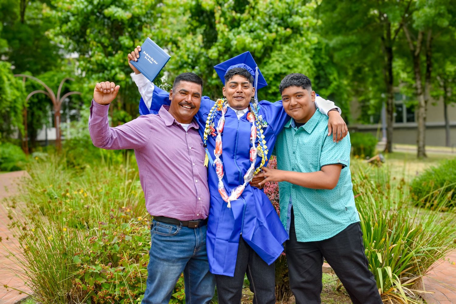 Senior graduate with family members wearing leis in a Tacoma park. Kent, Washington. Senior photography Seattle