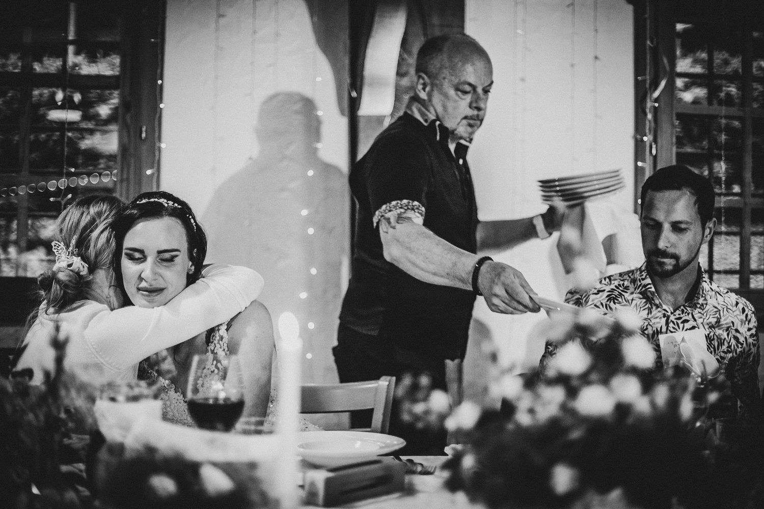 Black and white photo of servers pouring drinks at an elegant dinner reception.
