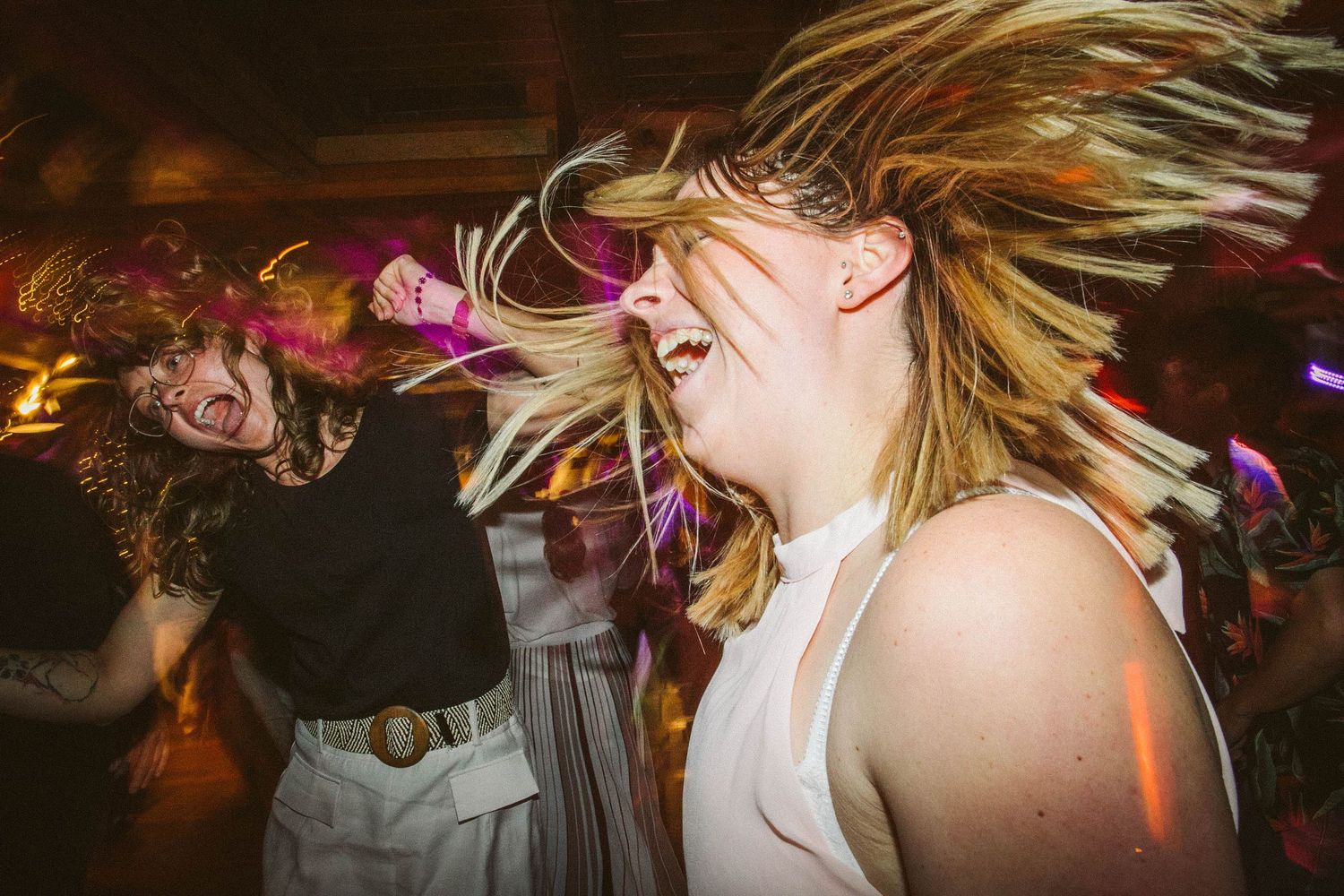 Dynamic photo of dancing with hair motion during energetic wedding reception celebration.