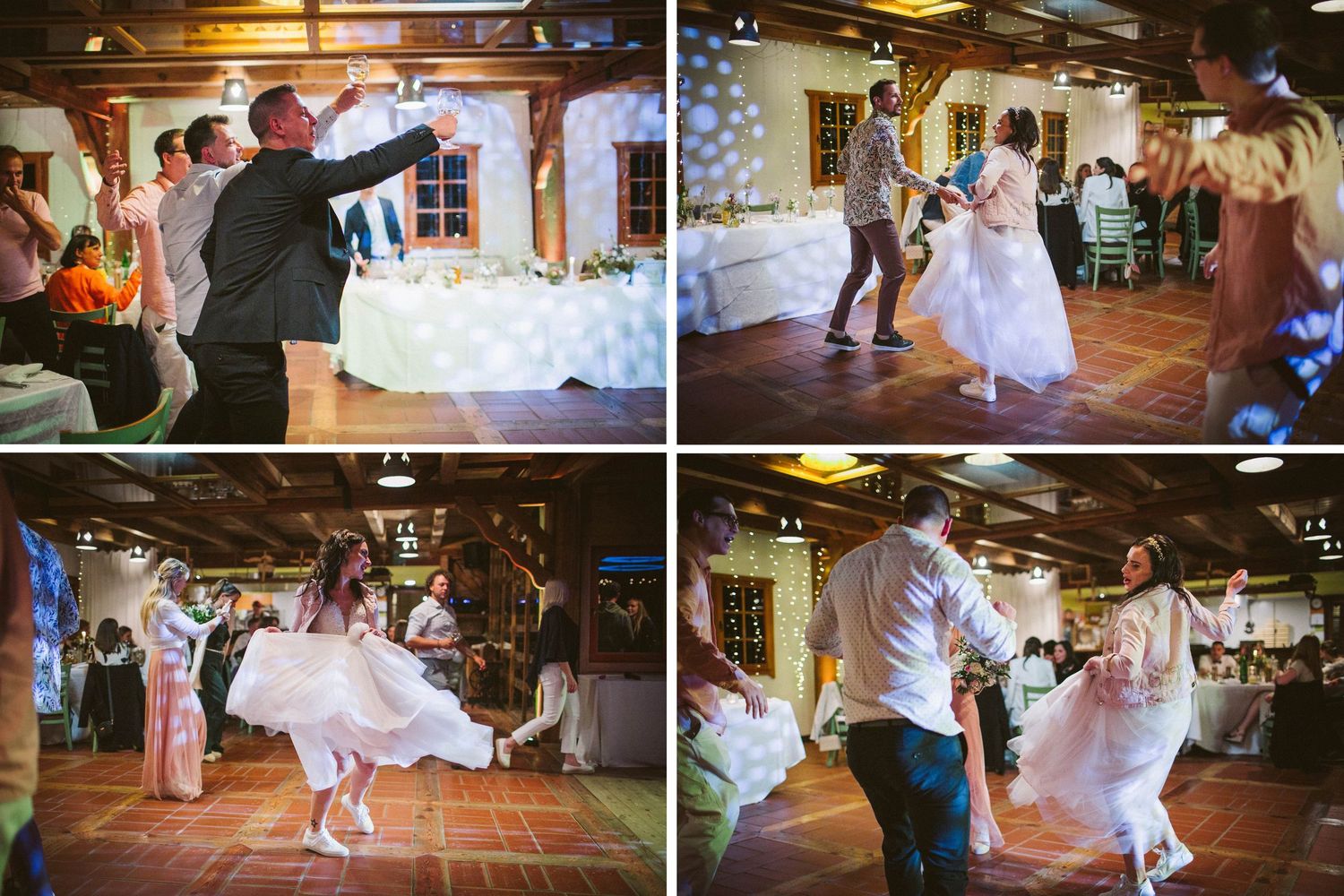 Wedding party dancing energetically in a rustic wooden reception venue with string lights.