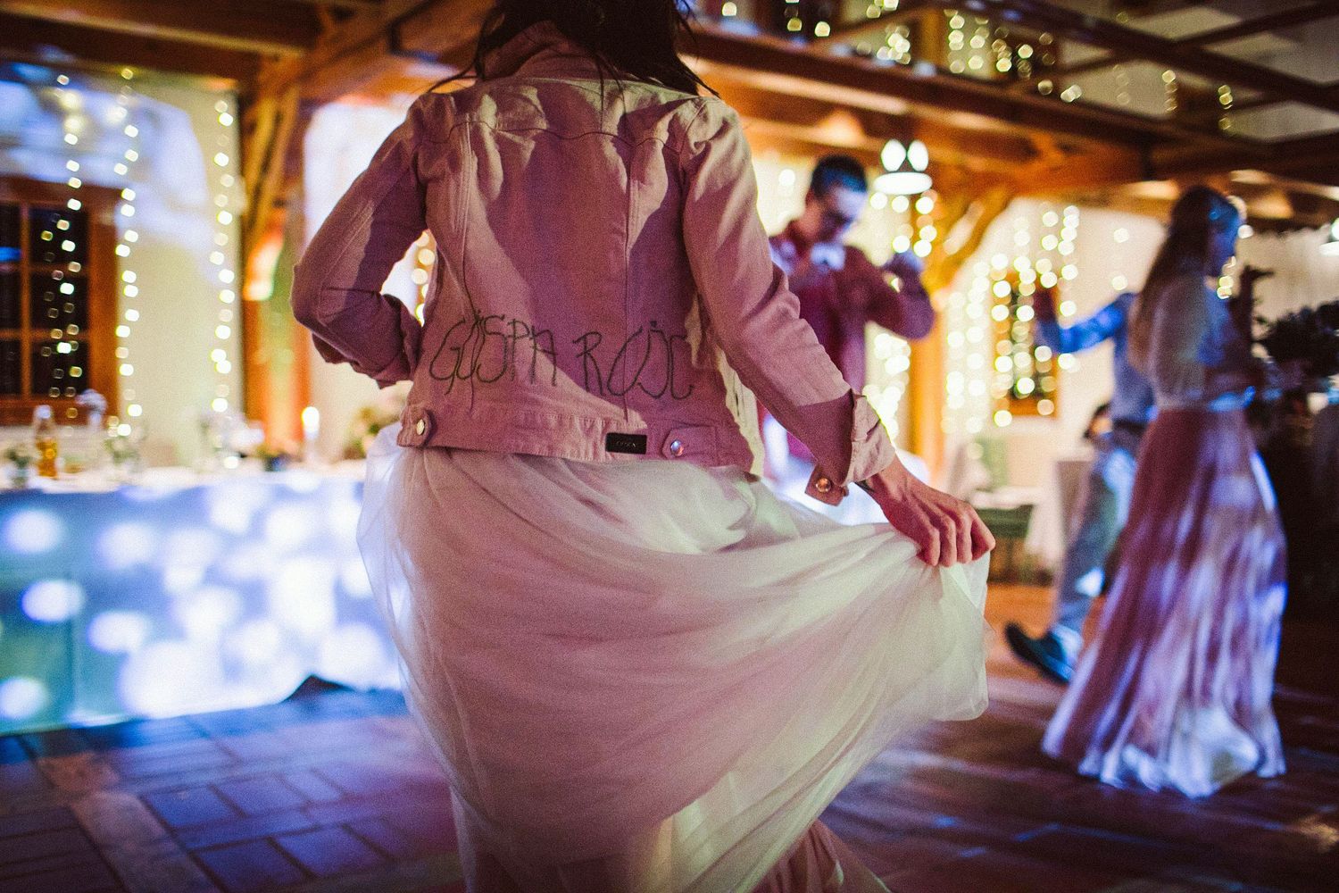 A swirling pink dress catches motion during a wedding dance celebration.