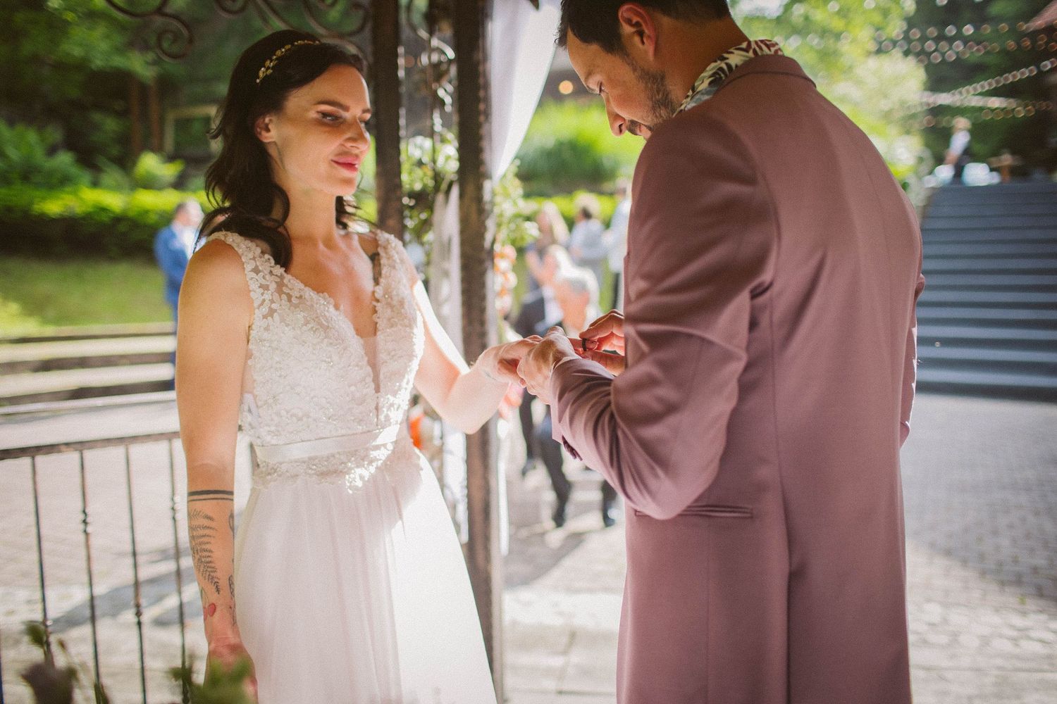 A tender moment during a wedding ceremony under a decorated gazebo.