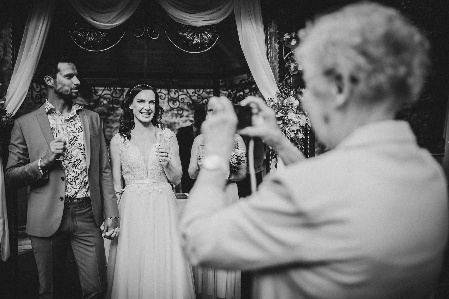 Black and white photograph capturing joyful reactions during a wedding ceremony.